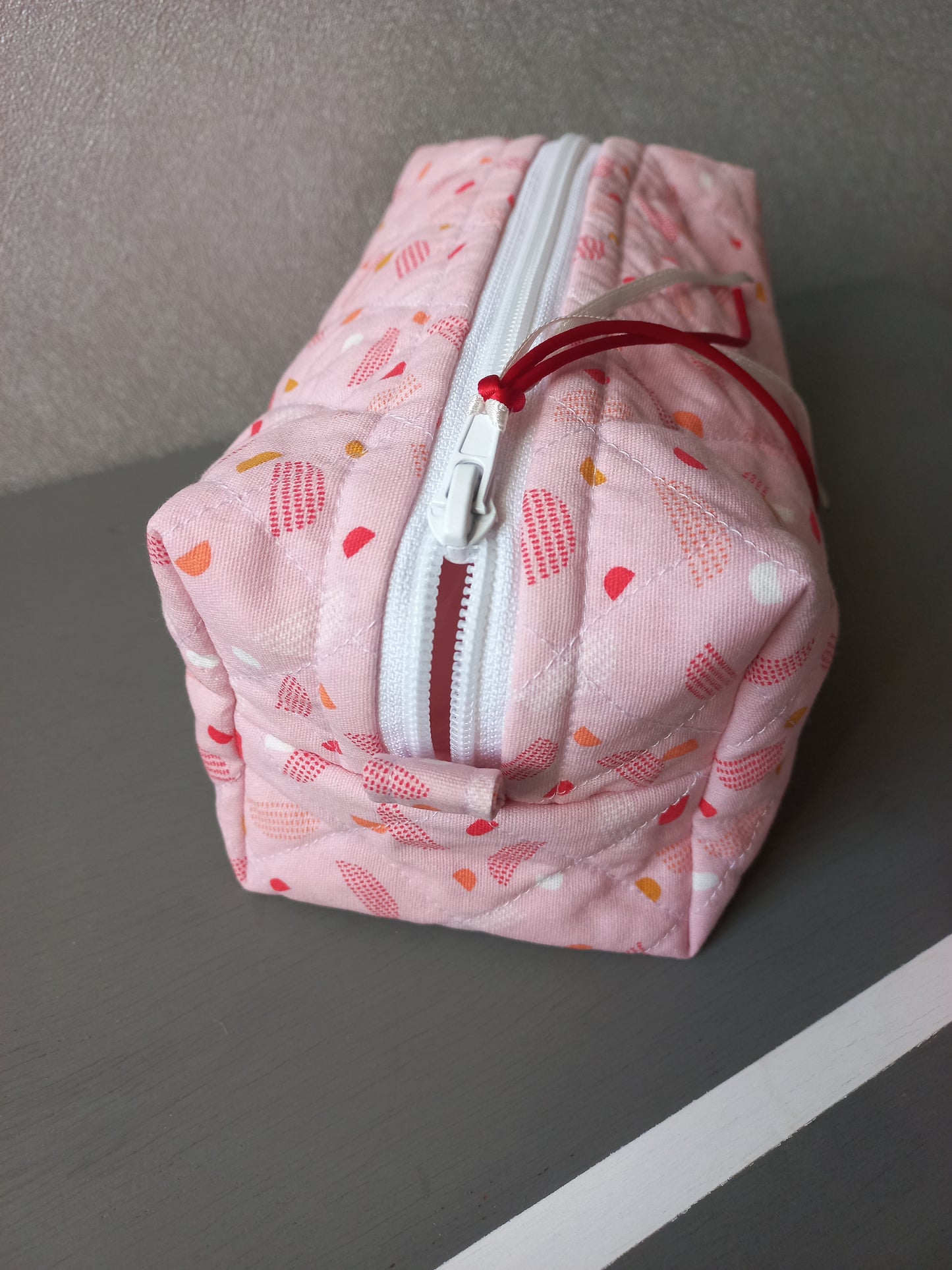 Trousse matelassée motifs géométriques roses